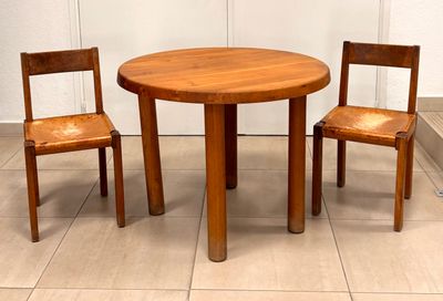 two wooden chairs and a table in a room