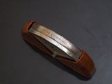 a brown leather tie bar with a silver buckle on it