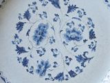 a blue and white plate with a floral design on it
