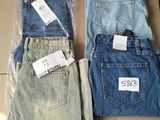 trois paires de jeans posées sur une boîte en carton