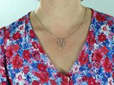 une femme qui porte un collier orné d'un cœur