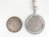 a silver coin and a silver coin sitting next to each other
