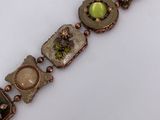an image of a close up of a bracelet on a white surface