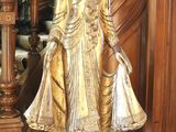 une statue représentant une femme debout devant un escalier