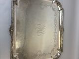 an antique silver tray with a handle on a white wall