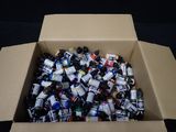 a cardboard box full of cans of beer on a black background