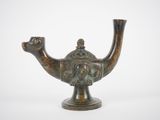 une petite théière en bronze sur laquelle est représenté un visage