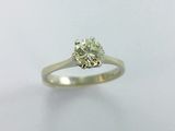 a close up of a diamond ring on a white surface