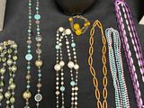 various necklaces and bracelets displayed on display on a black table