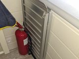 a fire extinguisher next to a fire hydrant in the corner of a room