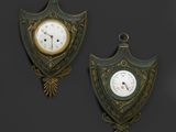 une paire d'horloges murales anciennes sur fond noir avec un arrière-plan sombre