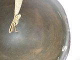 a metal pan with a handle on a white surface