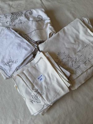 four napkins on a bed with embroidered designs on them