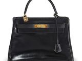 un sac à main en cuir noir avec des ferrures dorées sur la poignée