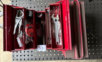 une boîte à outils rouge avec des outils sur une table