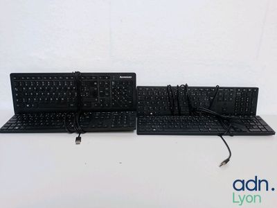two keyboards that are sitting on a white table