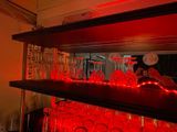 bottles and glasses are lined up on a shelf in a bar