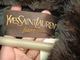 a person that is holding a brown label on a fur coat