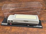 une petite maquette d'autobus dans une boîte transparente