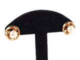 a close up of a pair of earrings on a black stand