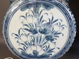 a blue and white vase with a lamp on a table