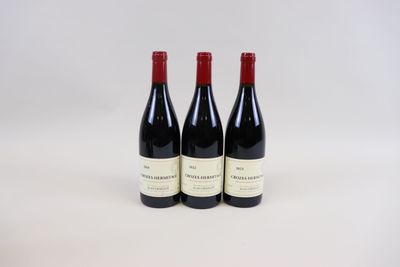 trois bouteilles de vin posées sur une table blanche