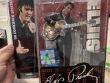 La figurine d'Elvis Presley se trouve dans une boîte, tenue par une main.