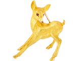broche représentant un cerf doré tenant un bâton dans la bouche, sur fond blanc