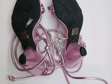 pair of pink high heeled shoes tied up to a white surface