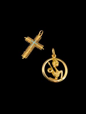 un pendentif en or orné d'une croix et un pendentif en or orné d'une croix