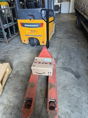 un chariot élévateur avec une caisse à son bord dans un entrepôt