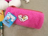 a pink purse with a heart on it next to a stuffed animal