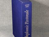 a blue book sitting on top of a table next to a gray wall