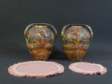 two vases and a coaster on a table with a black background