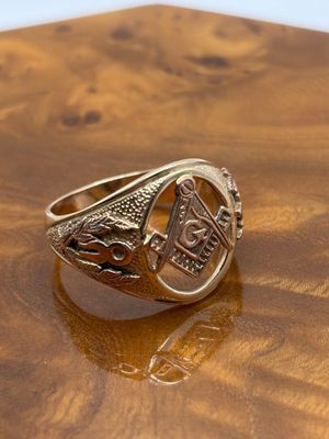 an image of a gold signet ring on a wooden surface