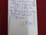 une note écrite sur un bout de papier posé sur une surface rouge
