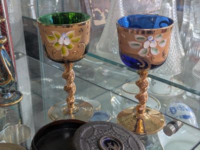 a glass display case with a couple of wine glasses on it