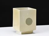 a small square vase with a hole in the middle