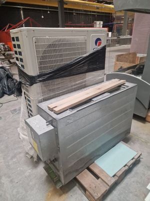un grand climatiseur posé sur une palette dans un entrepôt