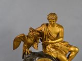 a statue of a man sitting on top of a clock