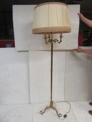 a man standing next to a lamp that is on a stand