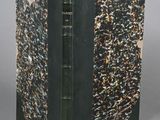 an old book with a black cover and a gold and black design