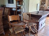 une table et des chaises en bois dans une pièce où est accroché un tableau au mur