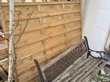 a wooden bench sitting in front of a wooden fence