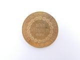 une pièce d'or sur une surface blanche avec un fond blanc