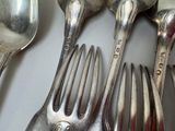a lot of silver spoons and spoons on the table