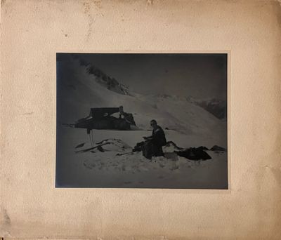 une photo en noir et blanc d'un homme assis dans la neige