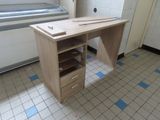 un bureau en bois avec des tiroirs, dans un coin de la pièce