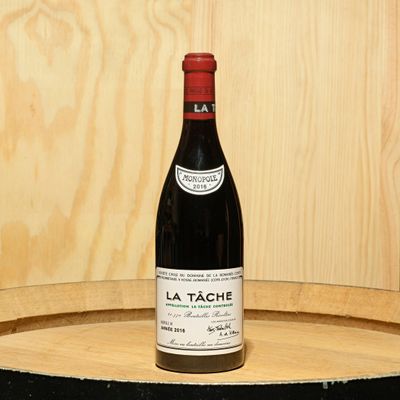 a bottle of wine sitting on top of a barrel