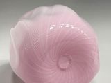 a pink ball of yarn sitting on a white surface